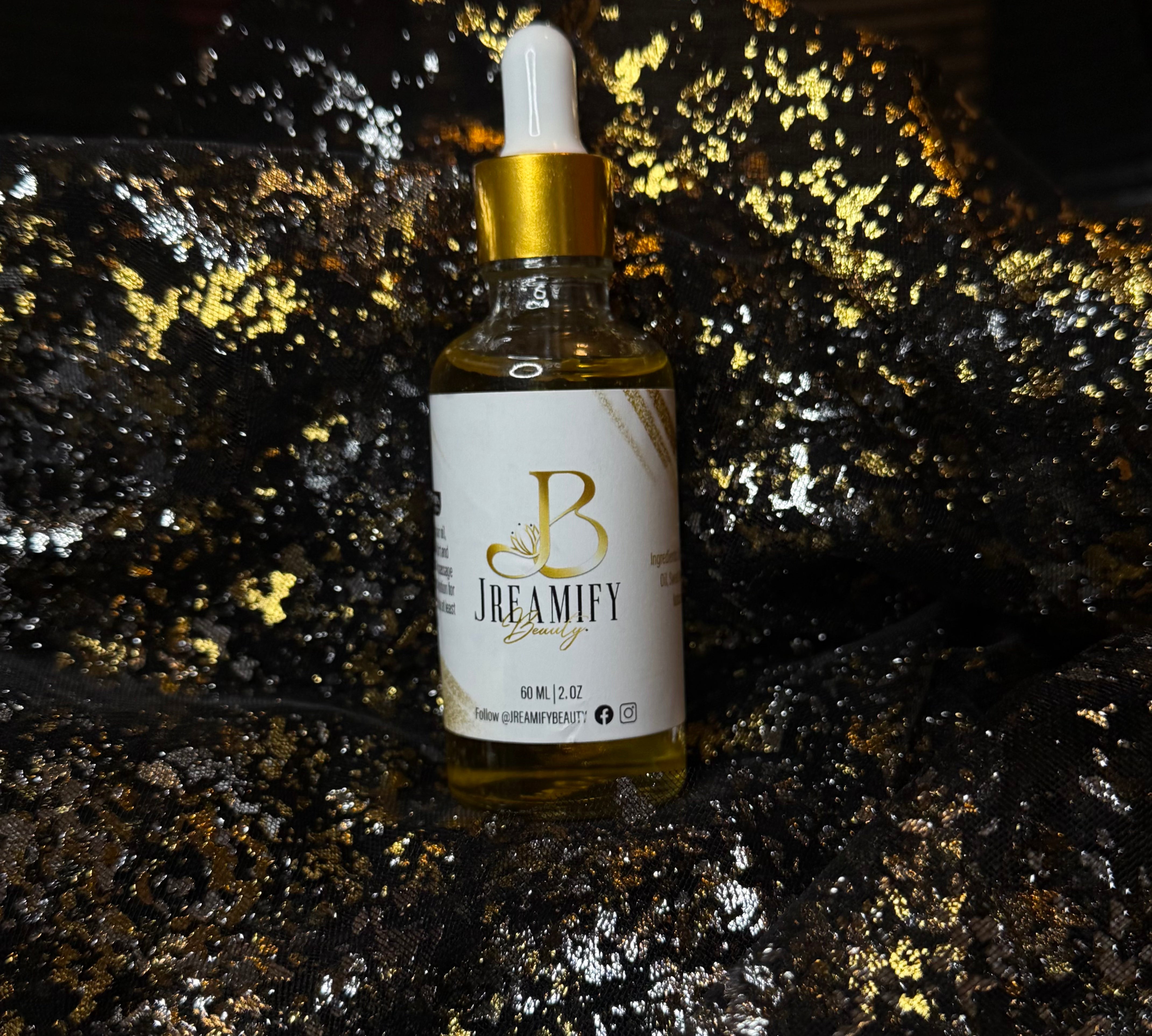 A bottle of Jreamify Hair serum with a white label and gold dropper cap, set against a dark glittery background.